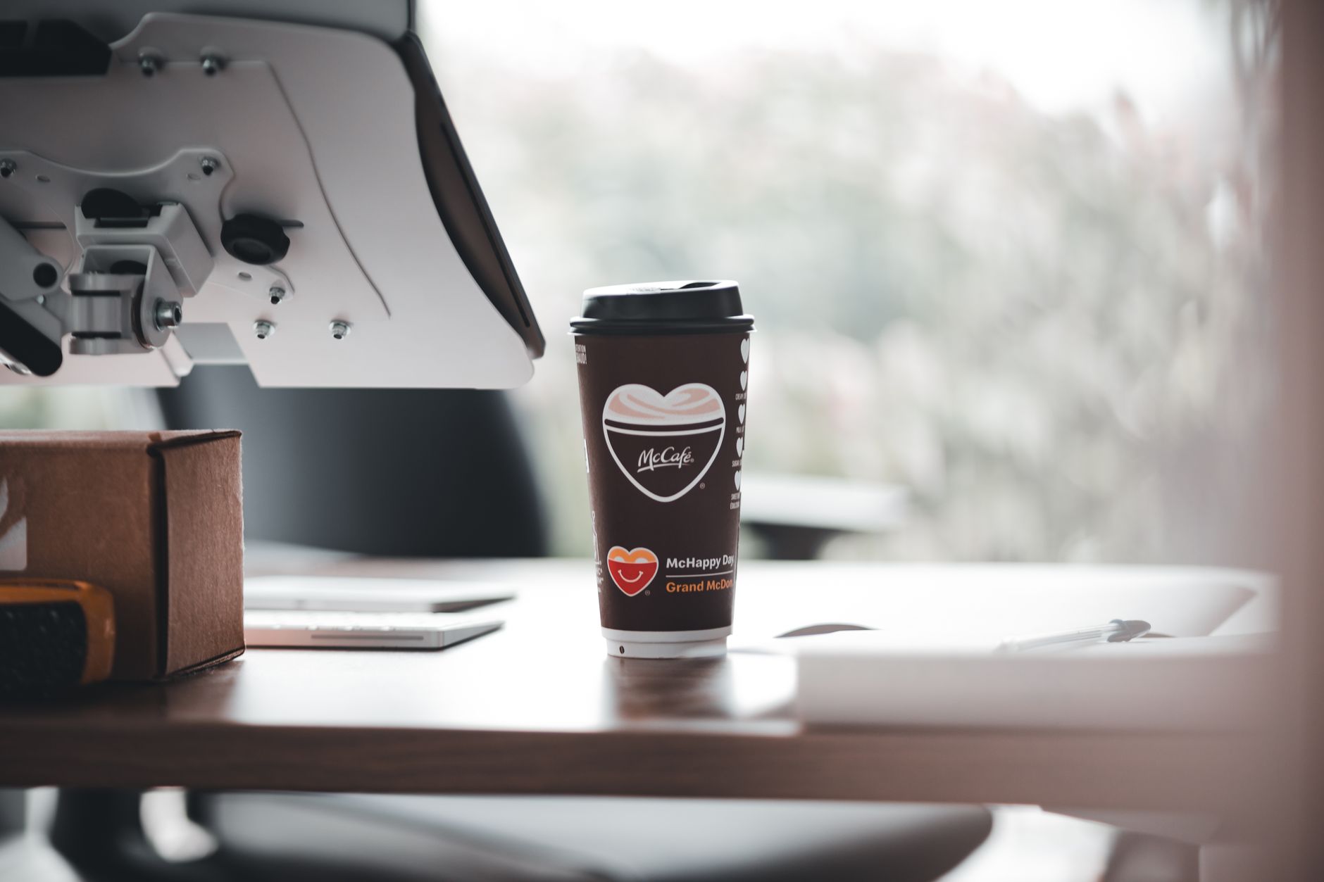 McCafe branded coffee cup on a modern office desk, creating a relaxed work ambiance.