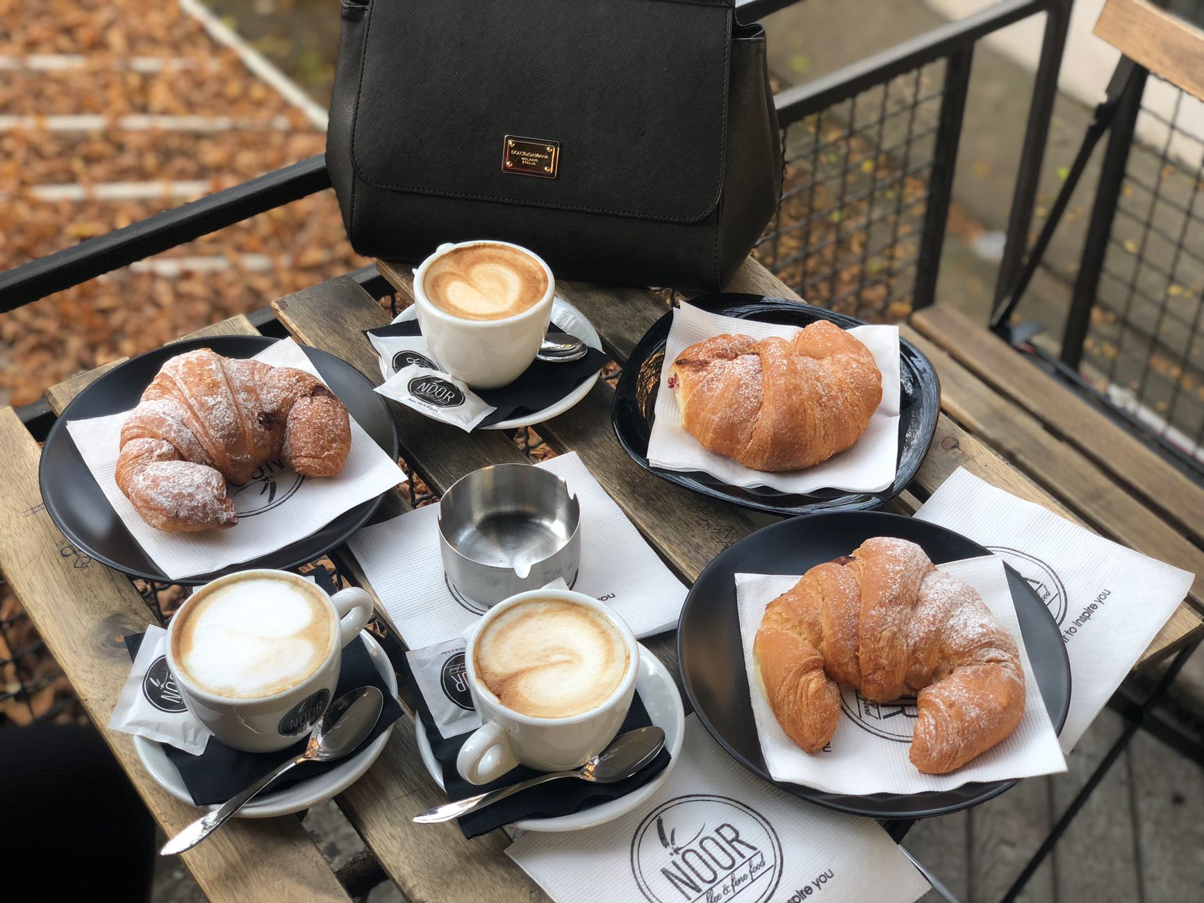 Enjoy a delightful breakfast with croissants and cappuccino at a cozy outdoor café table.