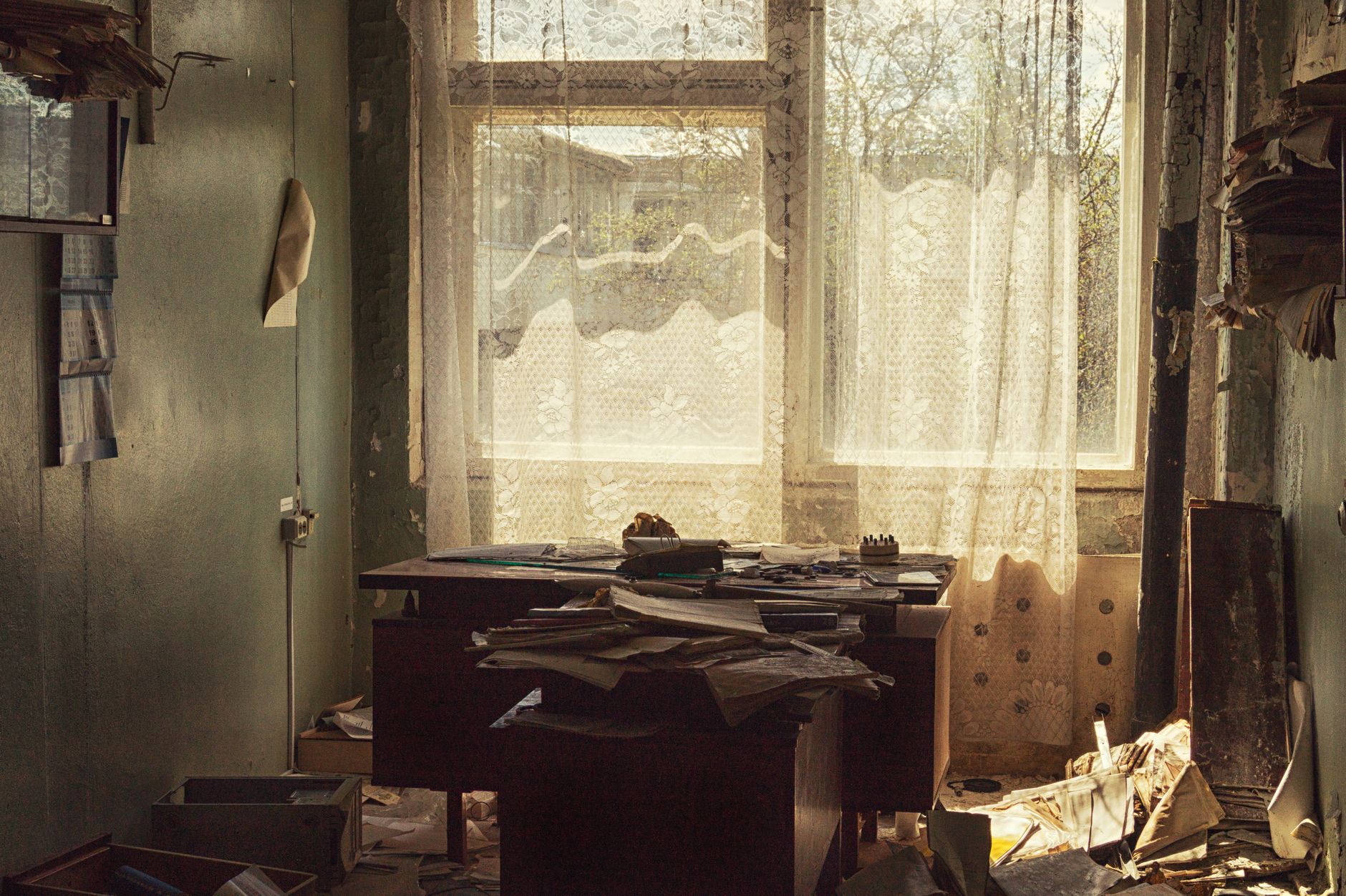 A deserted office with a sunlit window, dusty papers, and vintage decor capturing neglect and decay.