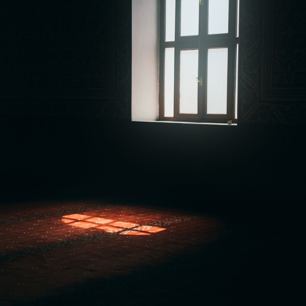 Soft sunlight beams through a window onto a patterned floor, creating a serene atmosphere.
